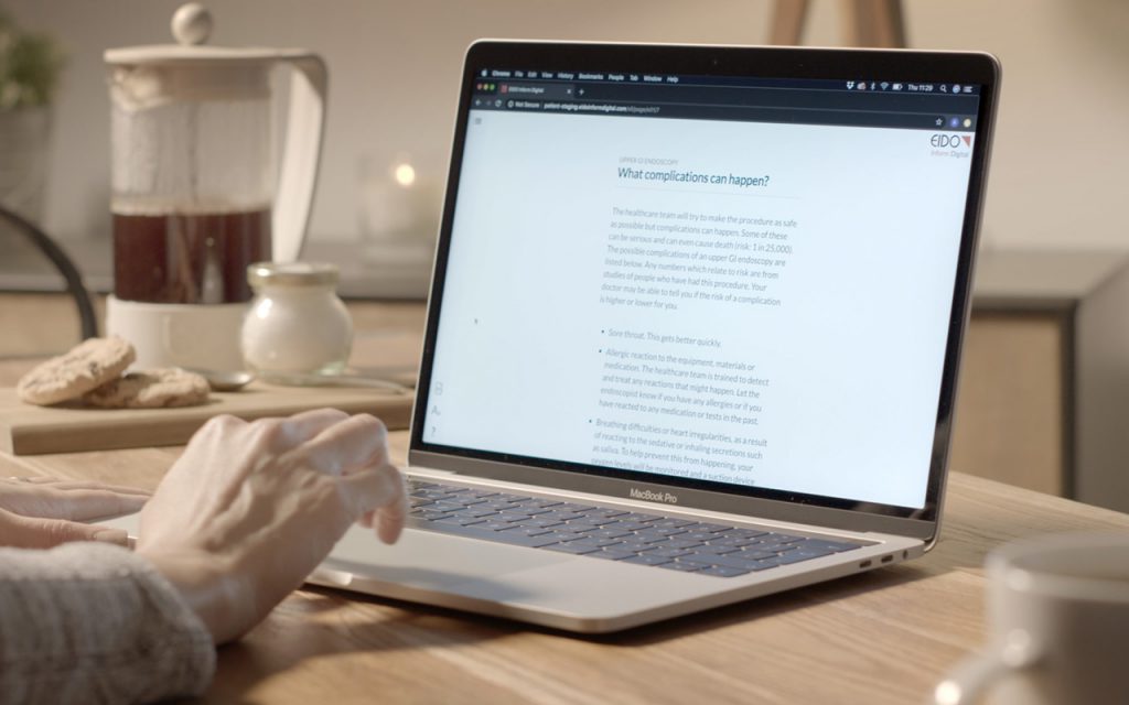 Somebody using a laptop that is displaying a medical document